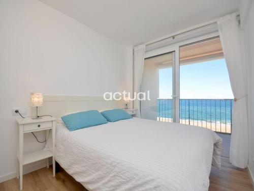 Dormitorio blanco con cama y ventana grande en Beach Palace B-2 en Platja  d'Aro