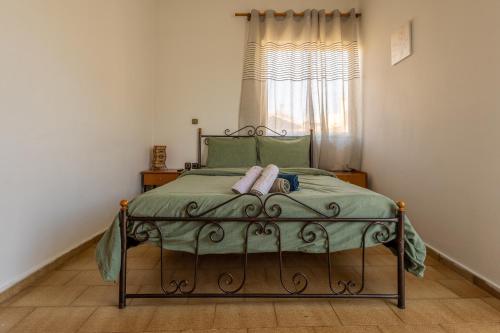 sypialnia z łóżkiem z zieloną pościelą i oknem w obiekcie Superior apartment LA w mieście Larisa