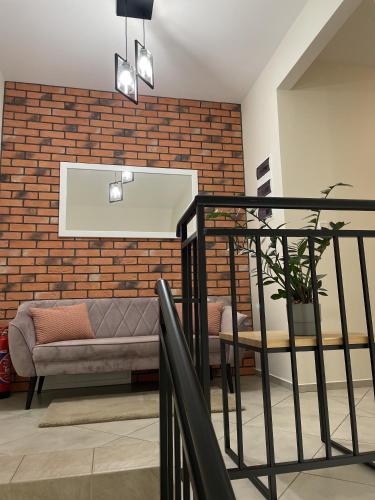 a living room with a couch and a brick wall at Dwór Bysina in Myślenice