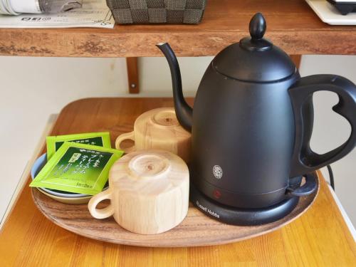 a black tea kettle on a plate on a table at Gardenvilla Shirahama in Shimoda