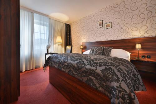 a hotel room with a bed and a window at Parkhotel Morris Novy Bor in Nový Bor