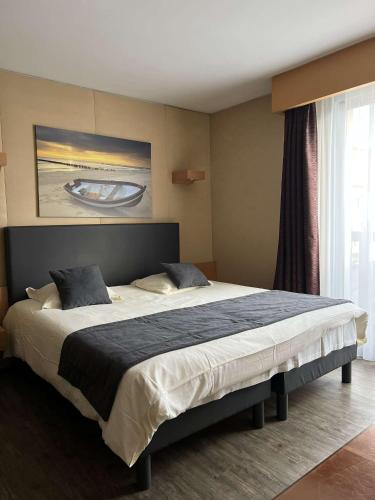 a bedroom with a large bed in a room at Amirauté Hôtel Golf Deauville in Deauville