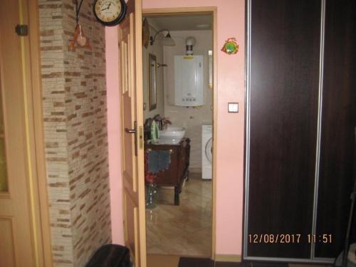 einen Flur, der zu einer Küche mit einer Uhr an der Wand führt in der Unterkunft Ferienhaus - a76547 in Kołobrzeg