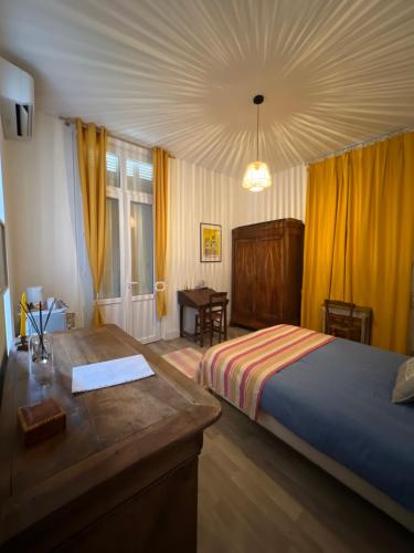 Chambre sur la falaise de Pontaillac في فو سور ميه: غرفة نوم بسرير ومكتب ونافذة