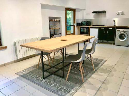 een keuken met een houten tafel en 2 stoelen bij Le Moulin in Mesland