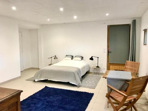 een slaapkamer met een bed en een blauw tapijt bij Le Moulin in Mesland