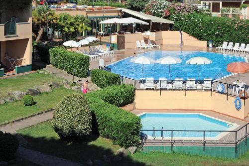 - une vue sur la piscine bordée de chaises et de parasols dans l'établissement Hotel Residence isola verde, à Marciana Marina