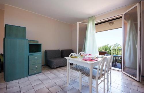 sala de estar con mesa con sillas y sofá en Hotel Residence isola verde en Marciana Marina