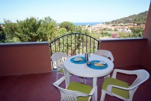 - Balcón con mesa blanca y sillas en Hotel Residence isola verde en Marciana Marina