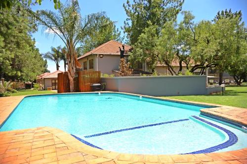 a large swimming pool in front of a house at Ultimate Sky-2 bedroom villa in Pretoria