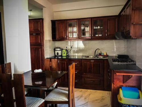 a kitchen with wooden cabinets and a black counter top at New Kandy Residence in Kandy