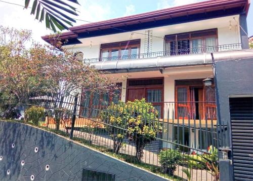 a house with a fence in front of it at New Kandy Residence in Kandy