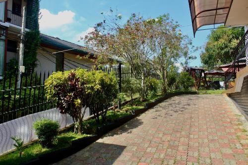 a brick road with trees and a fence at New Kandy Residence in Kandy