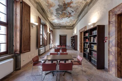 a row of tables and chairs in a library with a ceiling at PALAZZO DEL CAPITANO Wellness & Relais - Luxury Borgo Capitano Collection in San Quirico dʼOrcia