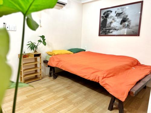 1 dormitorio con 1 cama con manta naranja en Cocal Home Phu Quoc Night Market, en Phu Quoc