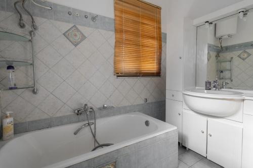 a bathroom with a bath tub and a sink at Delight apartment LA in Larisa