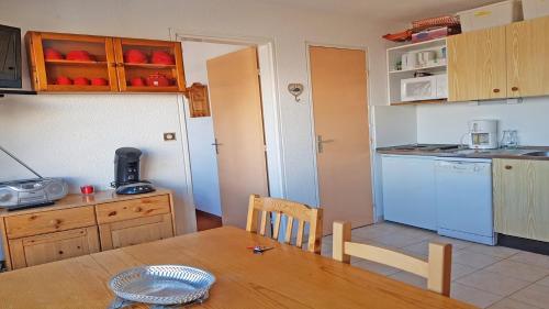 a kitchen with a table and a kitchen with a blue refrigerator at T2 PUY SAINT VINCENT in Puy-Saint-Vincent