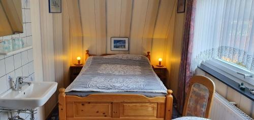 a small bedroom with a bed and a sink at Ferienwohnung-Martina in Sankt Peter-Ording