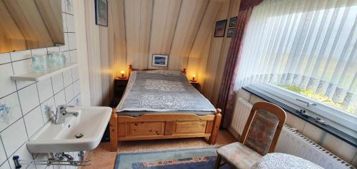 a small room with a bed and a sink at Ferienwohnung-Martina in Sankt Peter-Ording