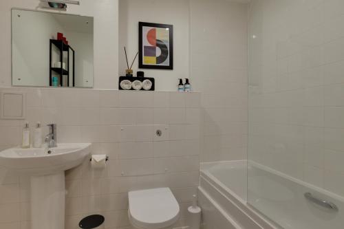 a white bathroom with a toilet and a sink at Central London - The Shoreditch, Angel, Old Street Apartment in London