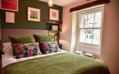 a bedroom with a green bed and a window at The Folly in Sedbergh