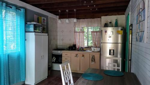 a small kitchen with a table and a refrigerator at Tierra Verde Bed & Breakfast in Bocas Town