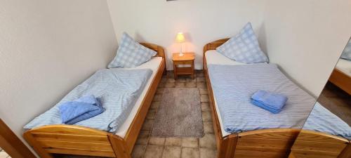 Dos camas en una habitación con almohadas azules. en FeWo-Hennings, en Olsdorf