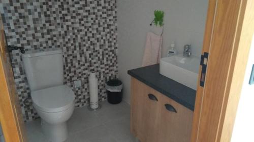 Un baño con un inodoro blanco y un lavabo. en Quinta da Fonte, en Torneira