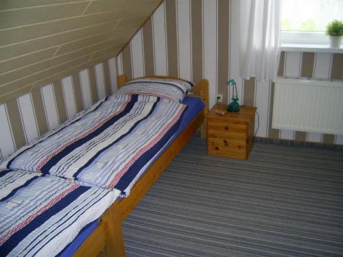 um quarto com uma cama, uma mesa e uma janela em Wohnung in Wilhelmsfehn mit Terrasse, Garten und Grill em Wiesmoor
