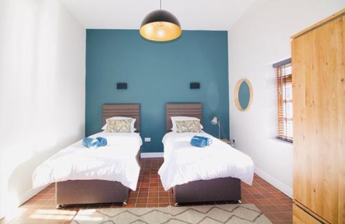 Duas camas num quarto com uma parede azul em 16 St Martins near to Steep Hill em Lincoln