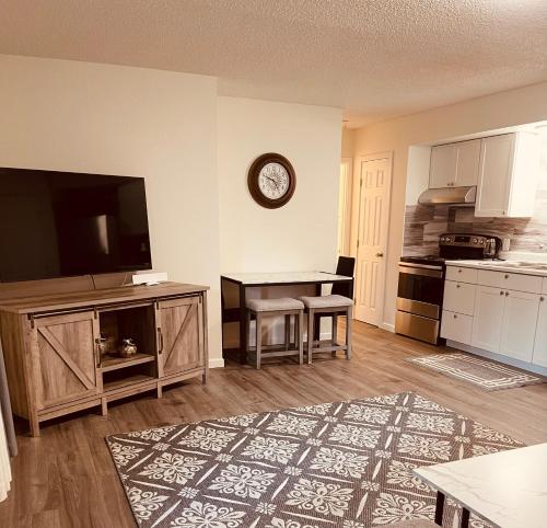 een woonkamer met een tv en een keuken met een tafel bij North Star Place 1 in Fairbanks