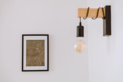 a picture hanging on a wall with a light at Idyllisches Landhaus mit Teich in Wielings