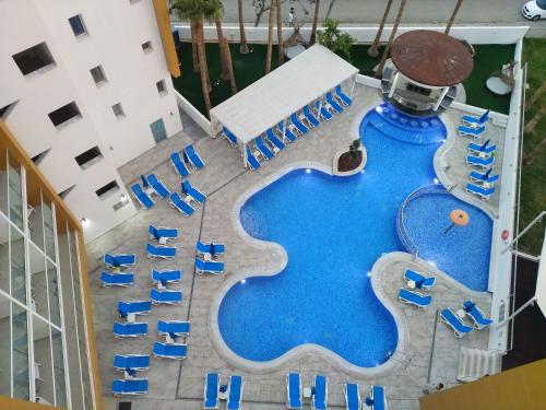 an overhead view of a swimming pool with blue chairs at Captain Pier Hotel in Protaras
