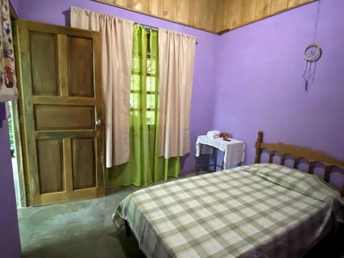 a bedroom with a bed and a door and a table at Casa Briza in Nicoya