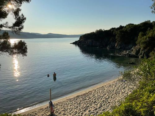 two people swimming in the water on a beach at Kis-Kis in Metókhion Ayías Kiriakís