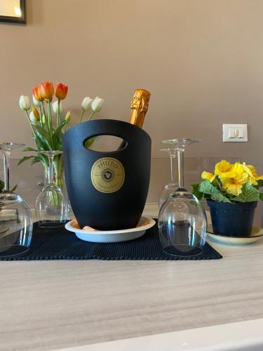 Una botella de champán en una olla sobre una mesa con flores en Appartamento Benaco a Milano - Fondazione Prada, en Milán