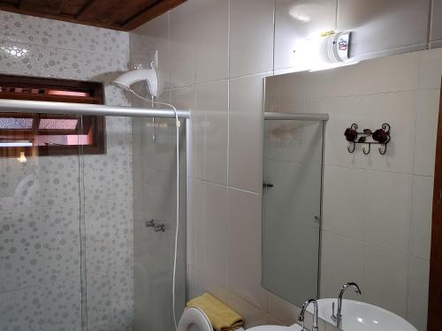a bathroom with a shower and a toilet and a sink at Chales Quinteto de Cores in Lavras Novas