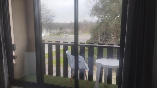 uma janela com uma cadeira e uma mesa numa varanda em Studio tout confort au bord du lac d'Estey em Dax