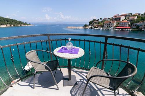 a table and chairs on a balcony with the water at Hotel ROYAL RINA in Stomorska