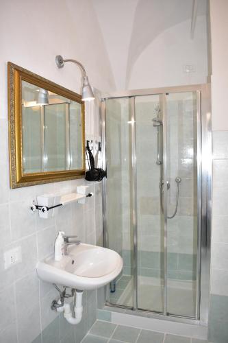 a bathroom with a sink and a glass shower at Appartamento magico nel centro del borgo L'ancora. in Laigueglia