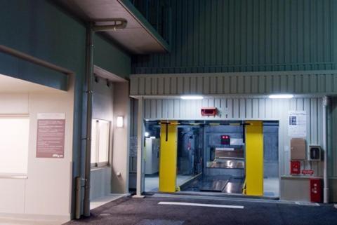 an empty garage with yellow doors in a building at Dormy Inn Tsu in Tsu