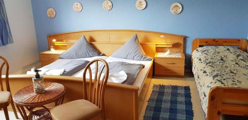una camera con letto, tavolo e sedie di Ferienwohnung-Floppy-Hansi-Fewo-4-EG a Sankt Peter-Ording
