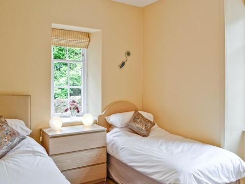 a bedroom with two beds and a window at Shepherds Cottage in Stenton