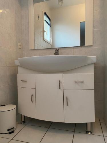 a bathroom with a white sink and a mirror at Maison PHILIPPE et Fils in Saint-Bonnet-près-Riom