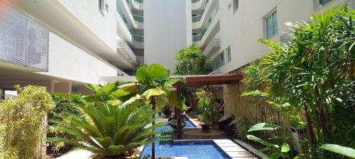 an external view of a building with a courtyard with palm trees at MANDAI Apartamento Cabo Frio in Cabo Frio