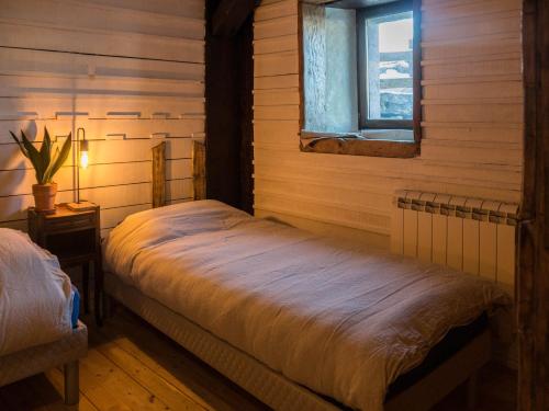 - une chambre avec un lit dans une pièce dotée d'une fenêtre dans l'établissement La luge, à Cormaranche-en-Bugey