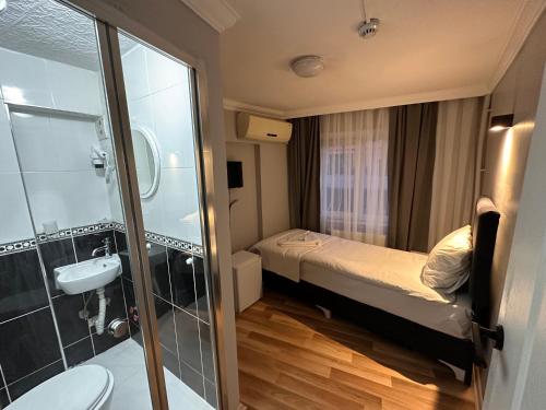 Un pequeño baño con una cama y un lavabo. en Asparagus HOTEL & SUITES OLD CITY, en Estambul