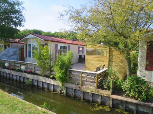 uma casa sobre a água com uma casa sobre um canal em dutchduochalet2 em Heenweg