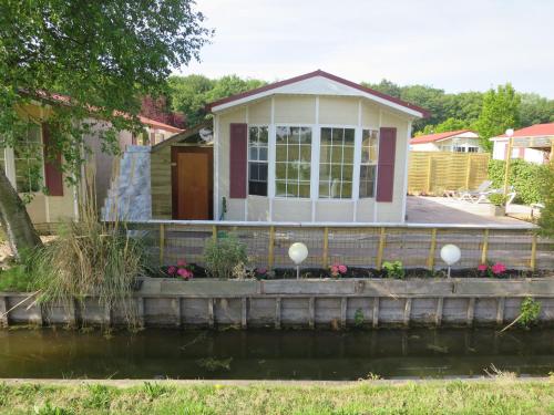 a house with a pond in front of it at dutchduochalet2 in Heenweg