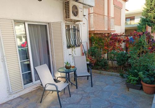 クサンティにあるSofia-Marina Guest Houseの建物の前にパティオ(椅子2脚、テーブル付)
